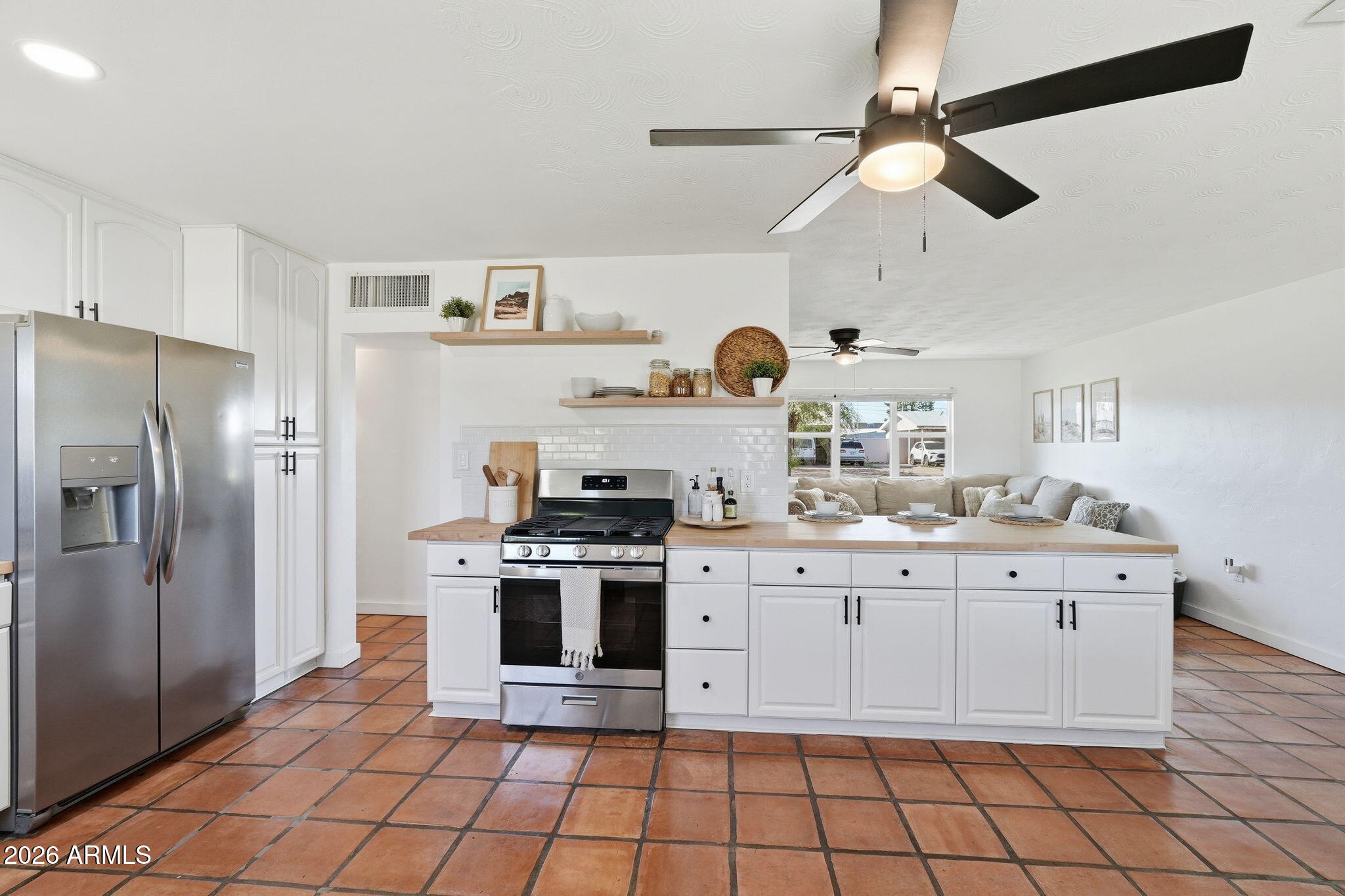 1052 West Elna Rae Street Tempe, AZ 85281 - Photo 2 of 16 a kitchen with stainless steel appliances a stove a sink and a refrigerator