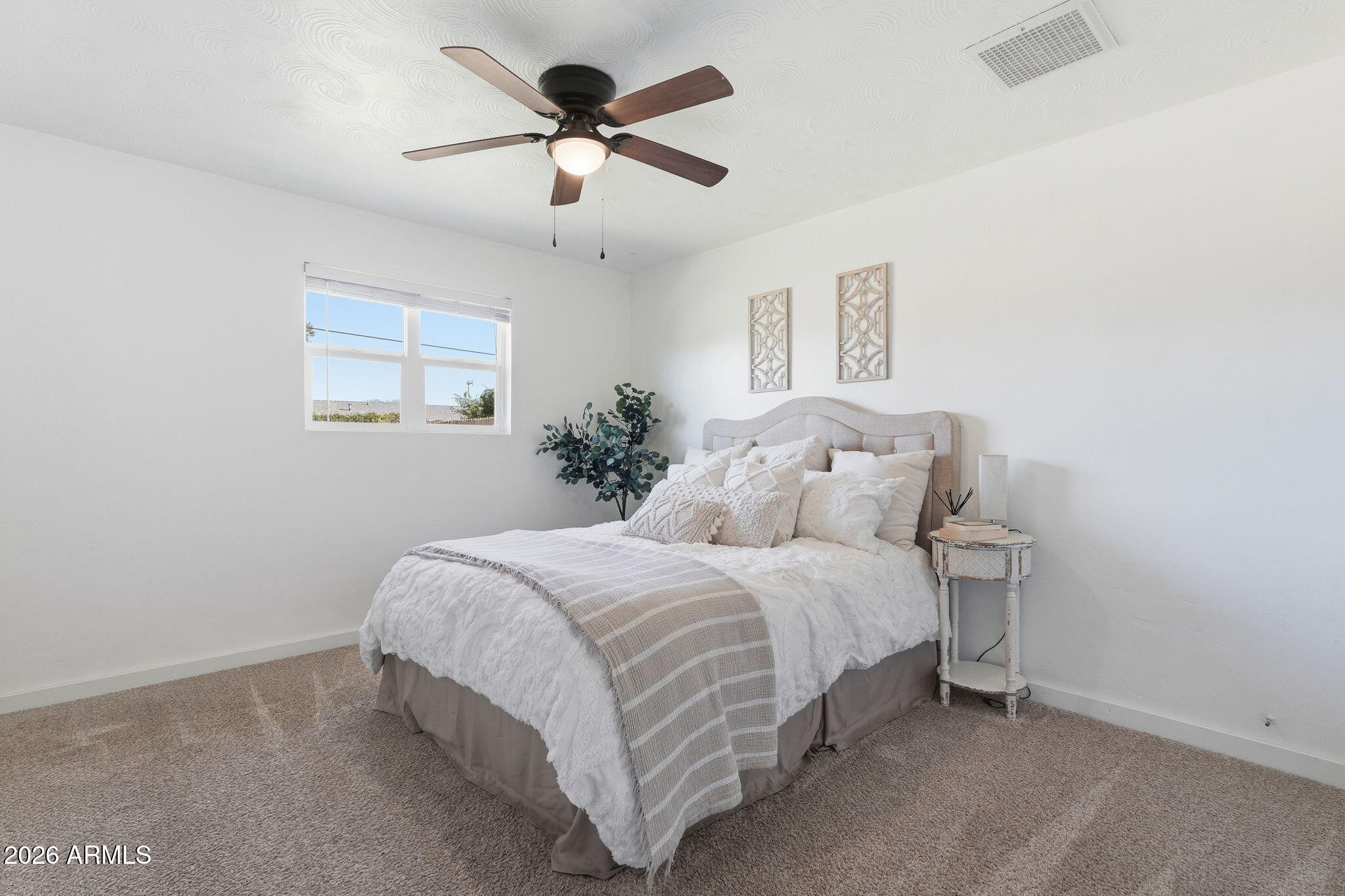1052 West Elna Rae Street Tempe, AZ 85281 - Photo 8 of 16 a bedroom with a large bed and a chandelier