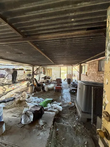 a view of a patio with table and chairs and a barbeque