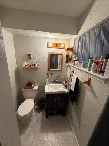 a bathroom with a sink a toilet and a mirror
