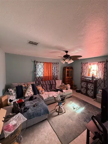 a living room with furniture fireplace and a large window