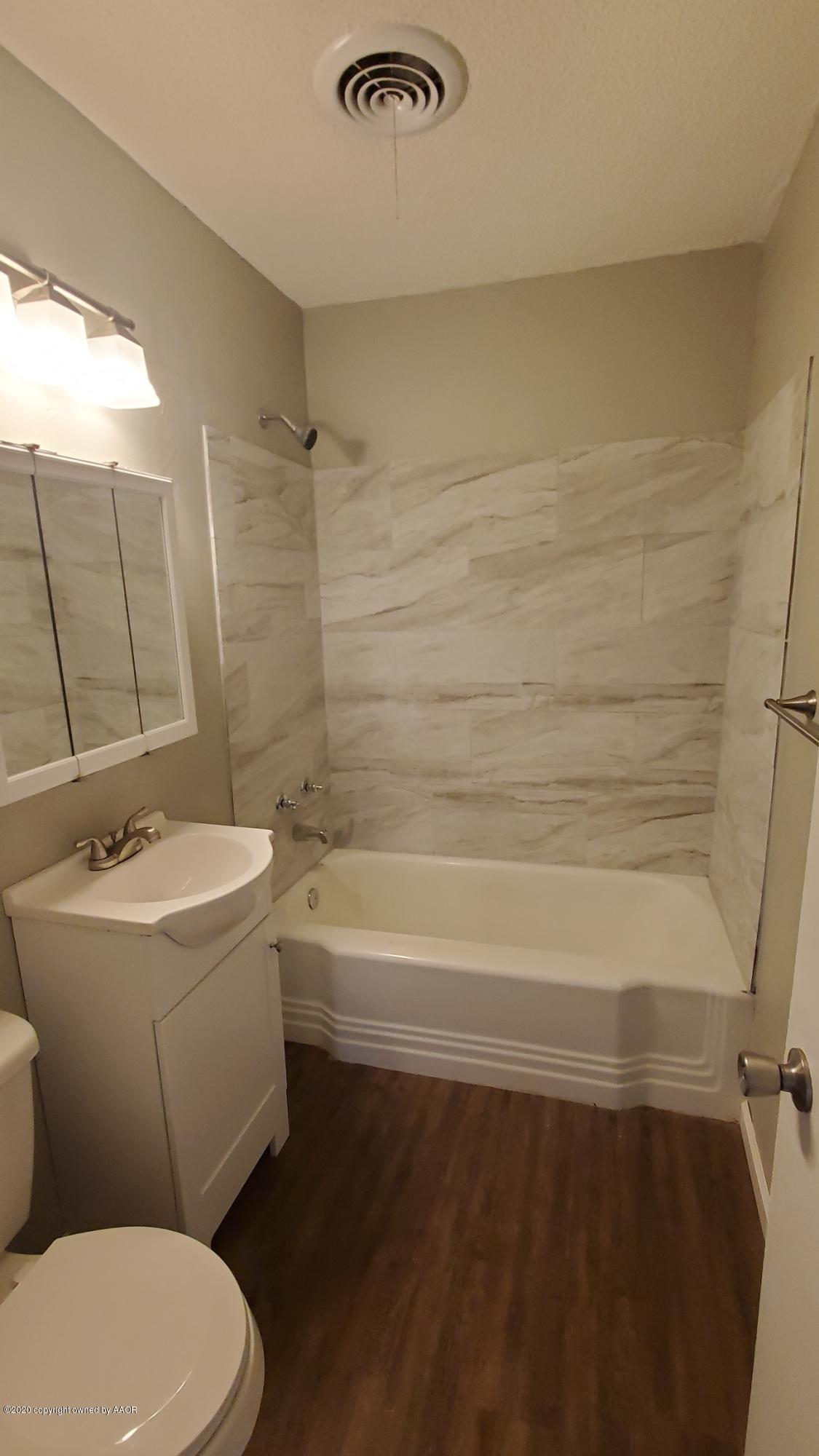 3809 South Jackson Street Amarillo, TX 79110 - Photo 13 of 17 a bathroom with a sink a toilet a mirror and bathtub
