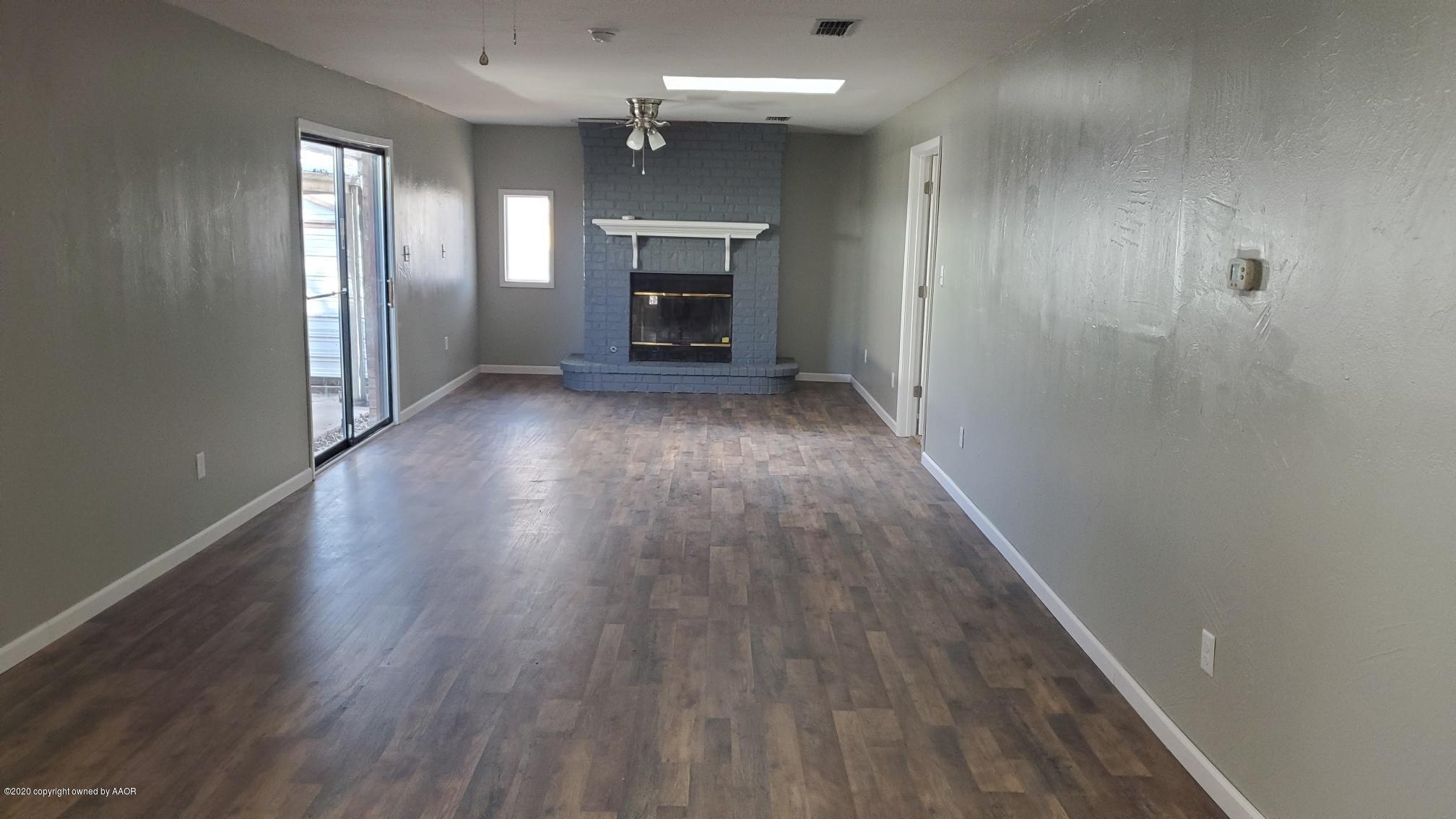 3809 South Jackson Street Amarillo, TX 79110 - Photo 4 of 17 an empty room with wooden floor and fireplace