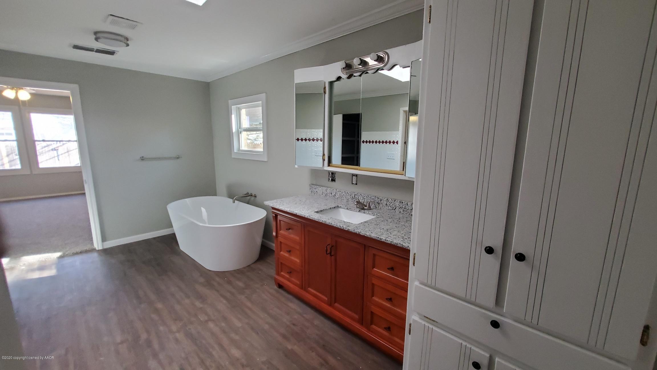 3809 South Jackson Street Amarillo, TX 79110 - Photo 8 of 17 a spacious bathroom with a granite countertop sink and mirror