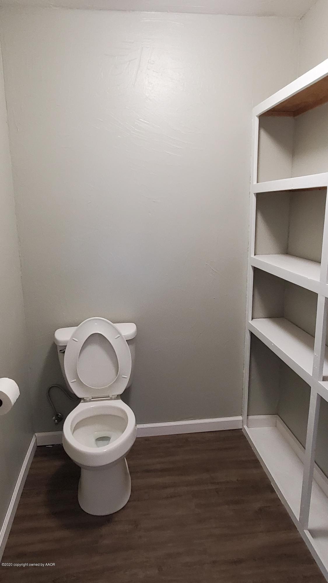 3809 South Jackson Street Amarillo, TX 79110 - Photo 10 of 17 a white toilet sitting next to a wooden cabinet