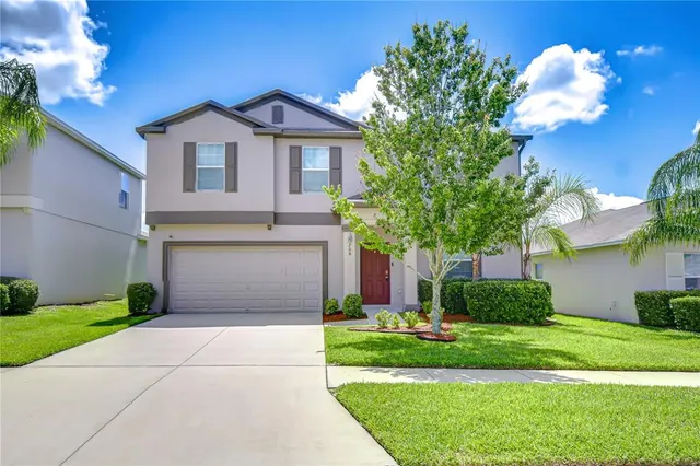 a front view of a house with a garden and plants