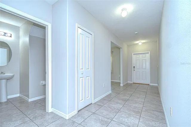 a view of a hallway with two mirror and a lamp