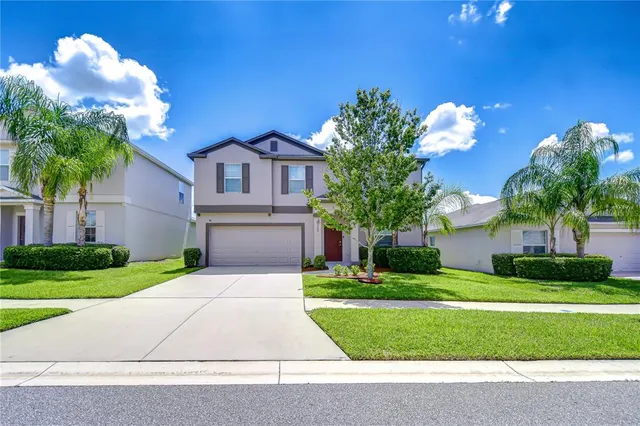 a front view of a house with a yard and garage
