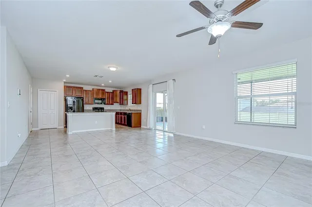 a large white kitchen with stainless steel appliances kitchen island granite countertop a refrigerator and a sink