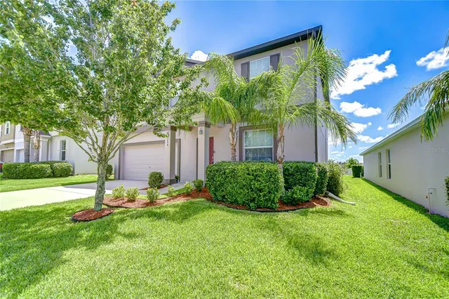 a view of a chair and table in backyard of the house