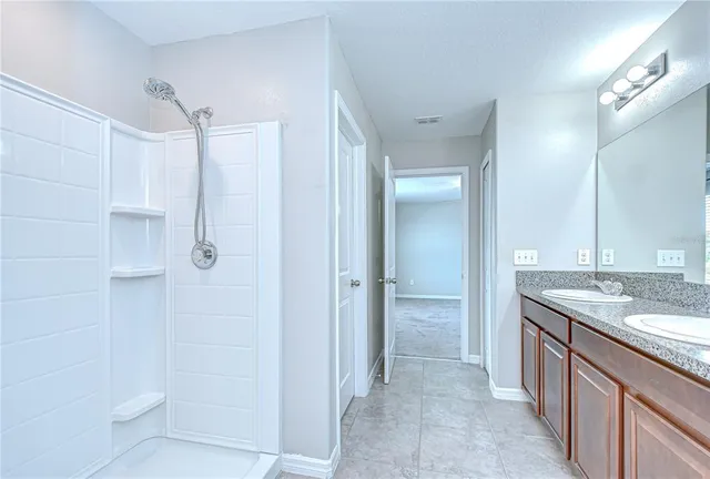 a bathroom with a granite countertop sink a toilet and a large mirror