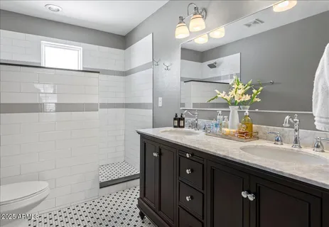 a bathroom with a sink a toilet and a mirror