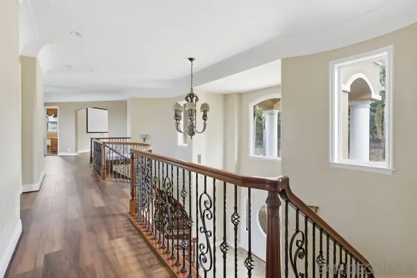 a view of a hallway with wooden floor and stairs