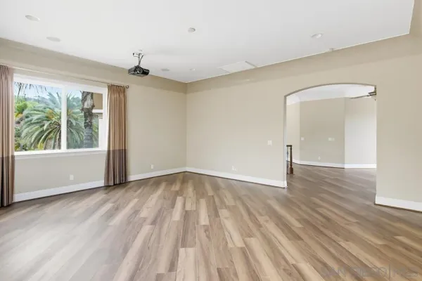 a view of empty room with wooden floor and fireplace