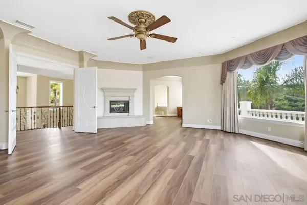 a large kitchen with stainless steel appliances granite countertop a stove a sink and a large window with wooden floor