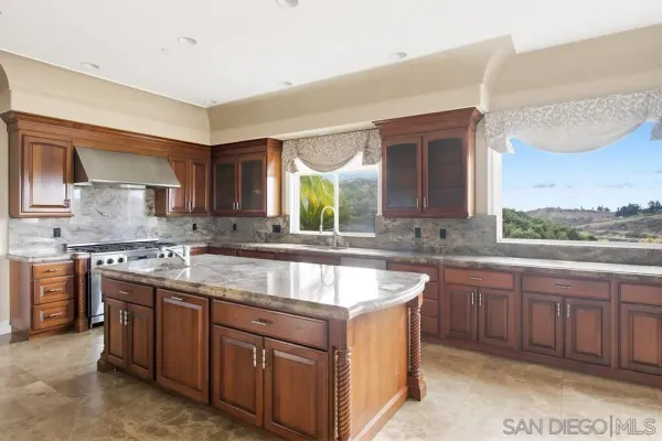 a kitchen with stainless steel appliances granite countertop a sink and a refrigerator