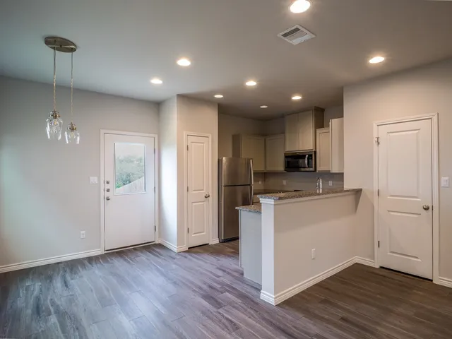 a kitchen with stainless steel appliances granite countertop a refrigerator and a stove top oven