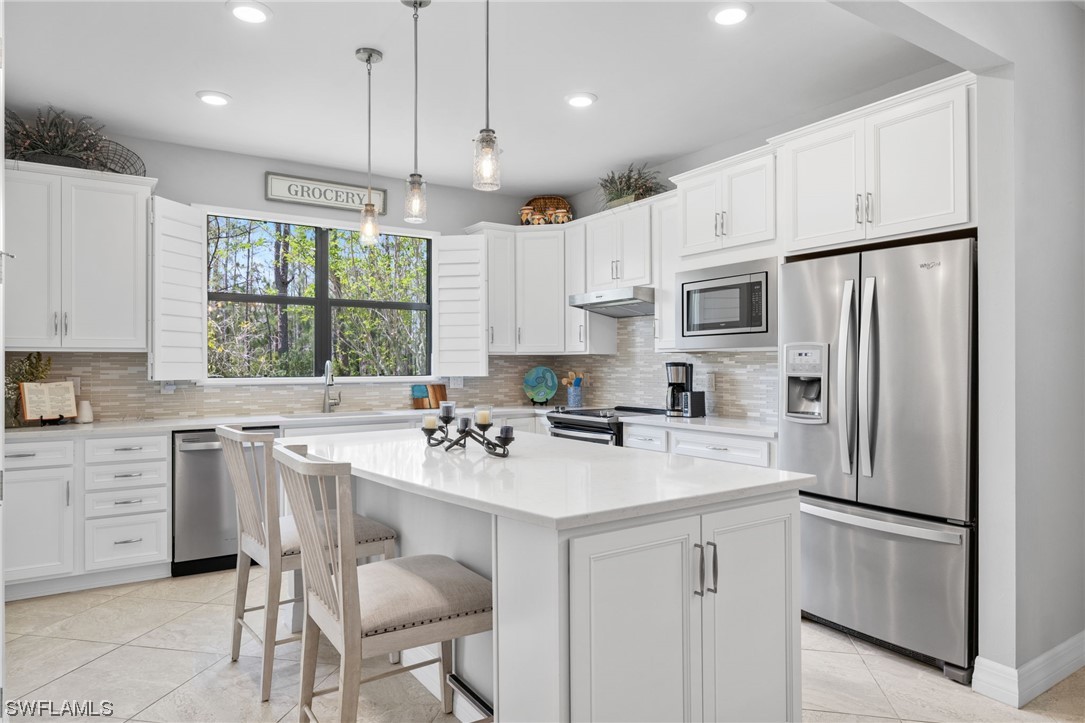 11237 Carlingford Road Fort Myers, FL 33913 - Photo 3 of 38 a kitchen with white cabinets and white appliances