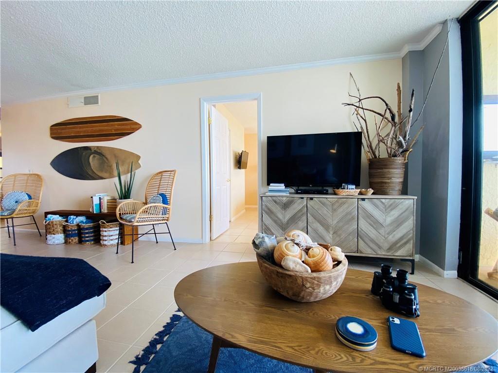 7380 South Ocean Drive, Unit 718A Jensen Beach, FL 34957 - Photo 18 of 58 a living room with furniture and a flat screen tv