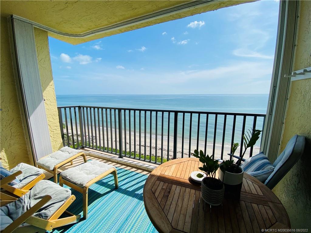 7380 South Ocean Drive, Unit 718A Jensen Beach, FL 34957 - Photo 26 of 58 a balcony with wooden floor table and chairs
