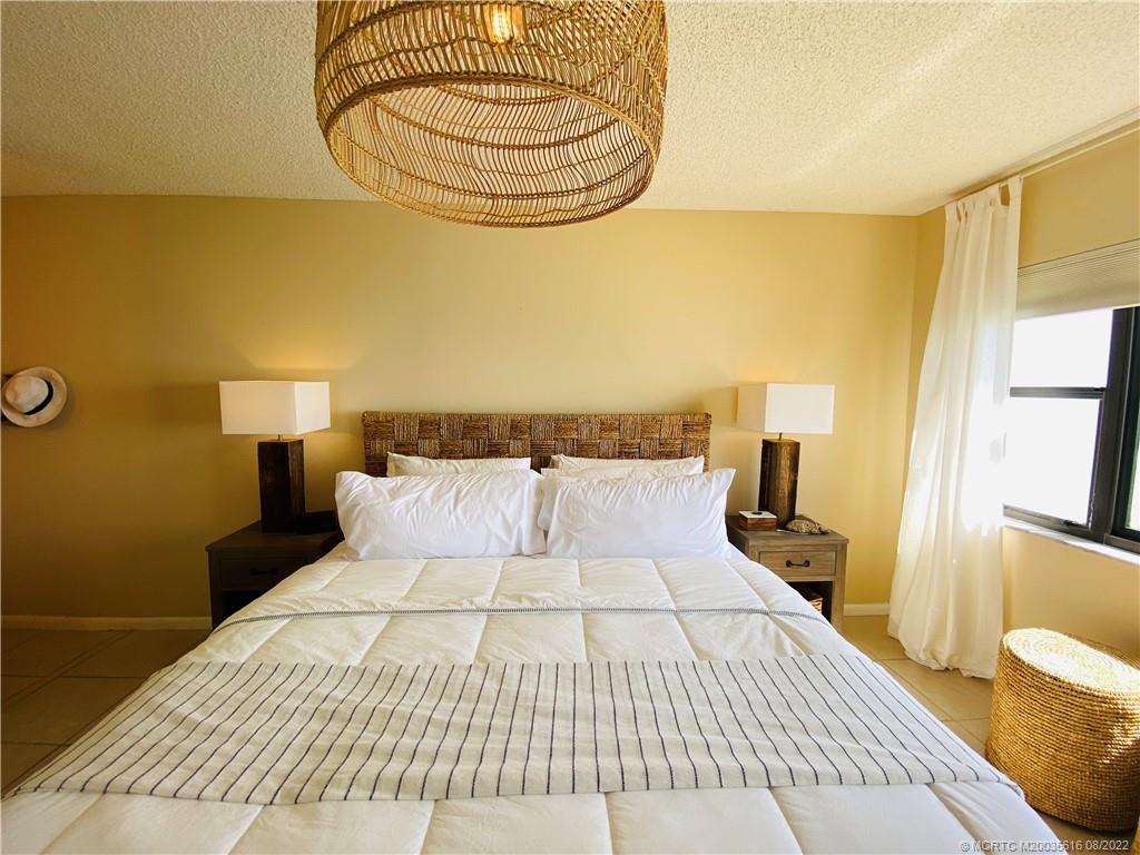 7380 South Ocean Drive, Unit 718A Jensen Beach, FL 34957 - Photo 29 of 58 a bedroom with a bed and wooden floor