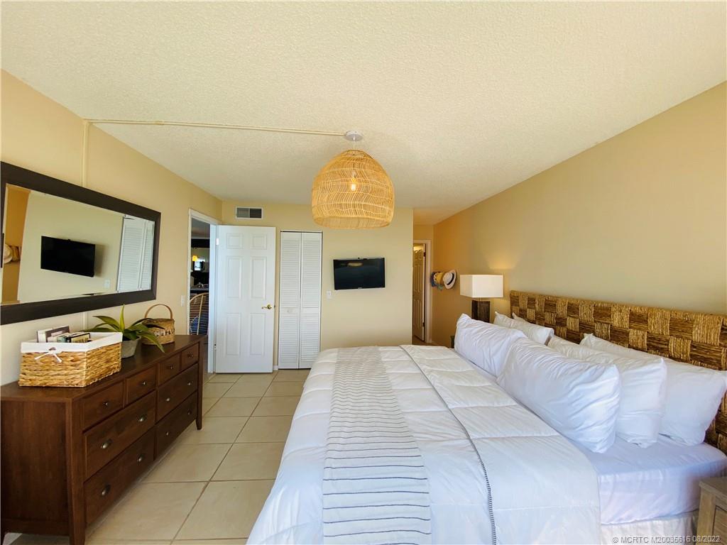 7380 South Ocean Drive, Unit 718A Jensen Beach, FL 34957 - Photo 31 of 58 a bedroom with a bed and a flat screen tv