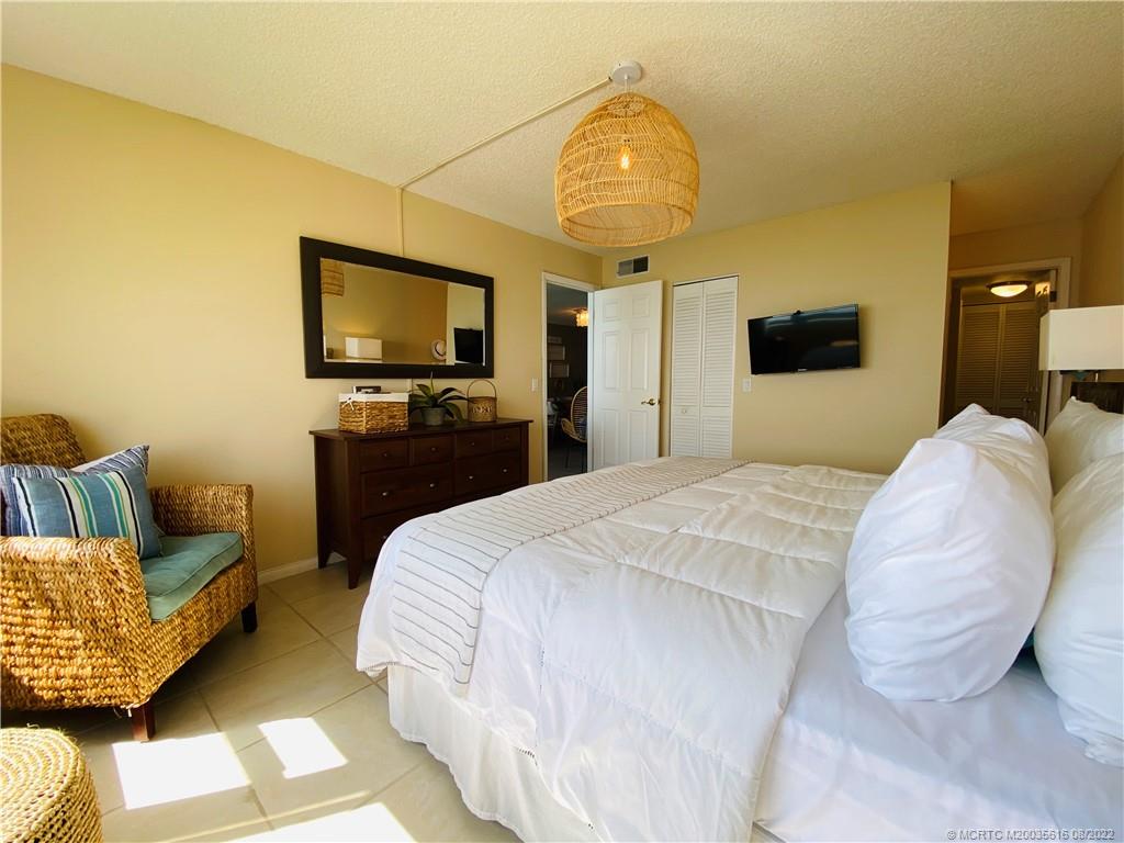 7380 South Ocean Drive, Unit 718A Jensen Beach, FL 34957 - Photo 32 of 58 a spacious bedroom with a bed and a flat screen tv