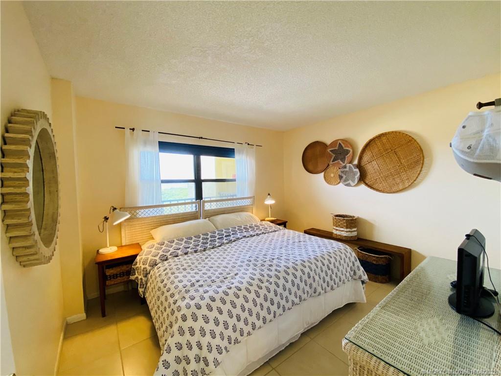 7380 South Ocean Drive, Unit 718A Jensen Beach, FL 34957 - Photo 42 of 58 a bedroom with a bed and dresser