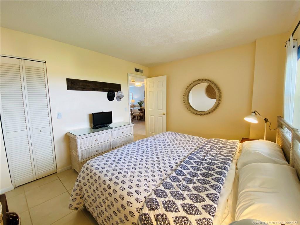 7380 South Ocean Drive, Unit 718A Jensen Beach, FL 34957 - Photo 44 of 58 a bedroom with a bed and a mirror