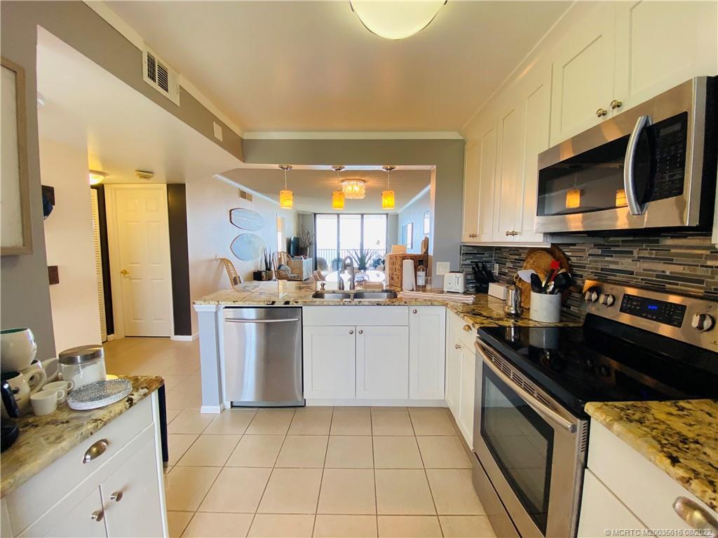 7380 South Ocean Drive, Unit 718A Jensen Beach, FL 34957 - Photo 7 of 58 a kitchen with a sink stove and microwave