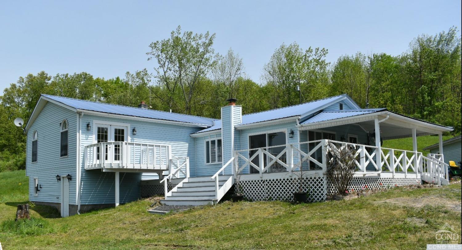 a view of a house with a yard and deck area