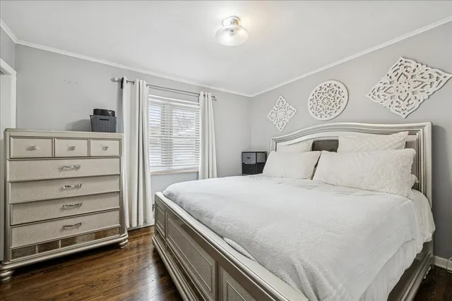 a bedroom with a bed a flat screen tv and a couch