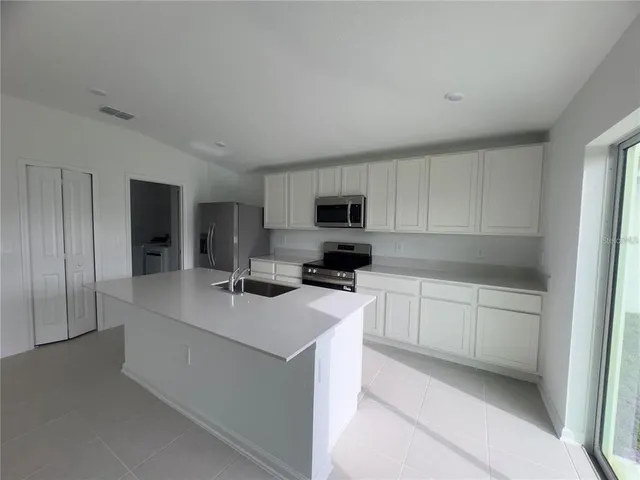 a kitchen with cabinets stainless steel appliances and a counter space