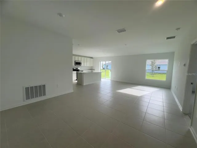 a view of empty room with a window and wooden floor