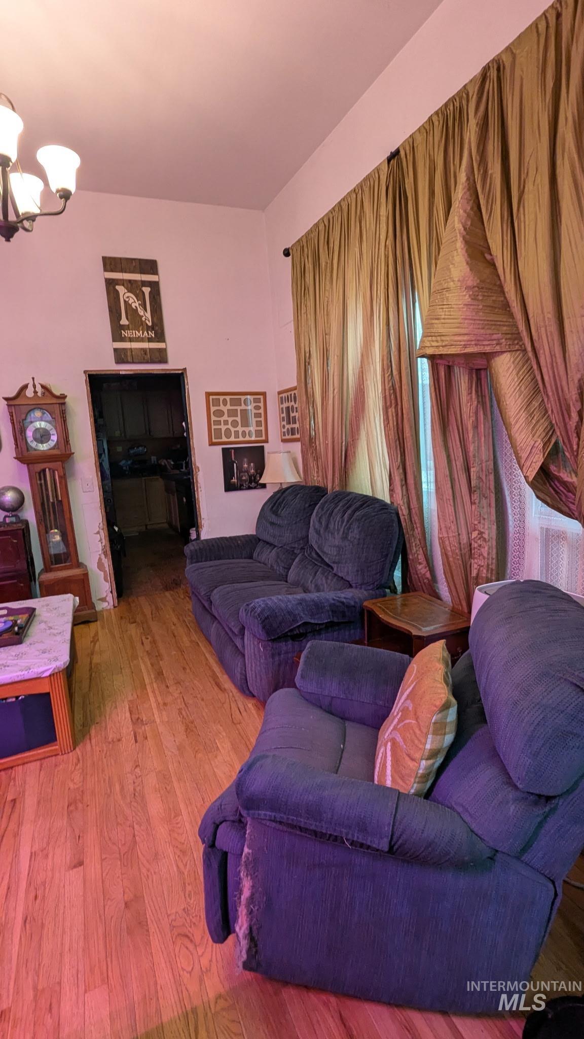 411 South Pine Street Troy, ID 83871 - Photo 2 of 10 Living room featuring wood finished floors and a chandelier