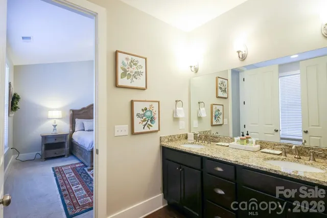 a bathroom with a granite countertop sink a toilet a shower and a mirror