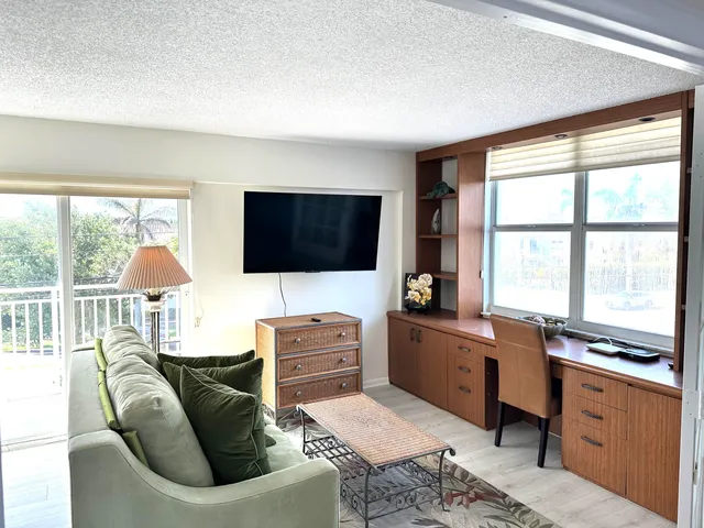 a living room with furniture tv and a large window