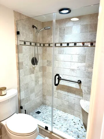 a bathroom with a shower a toilet and a sink