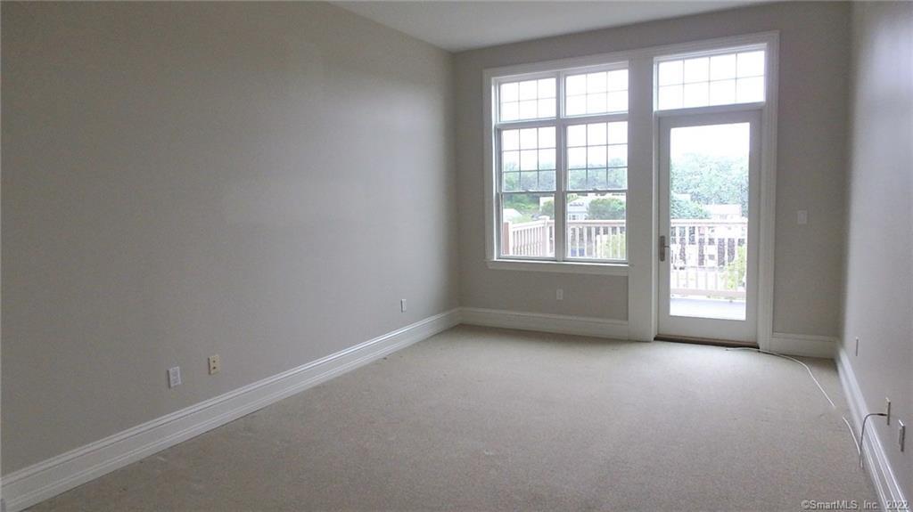 75 Stone Ridge Way, Unit 3E Fairfield, CT 06824 - Photo 7 of 23 Primary bedroom includes patio, two large closets, and primary bathroom suite.