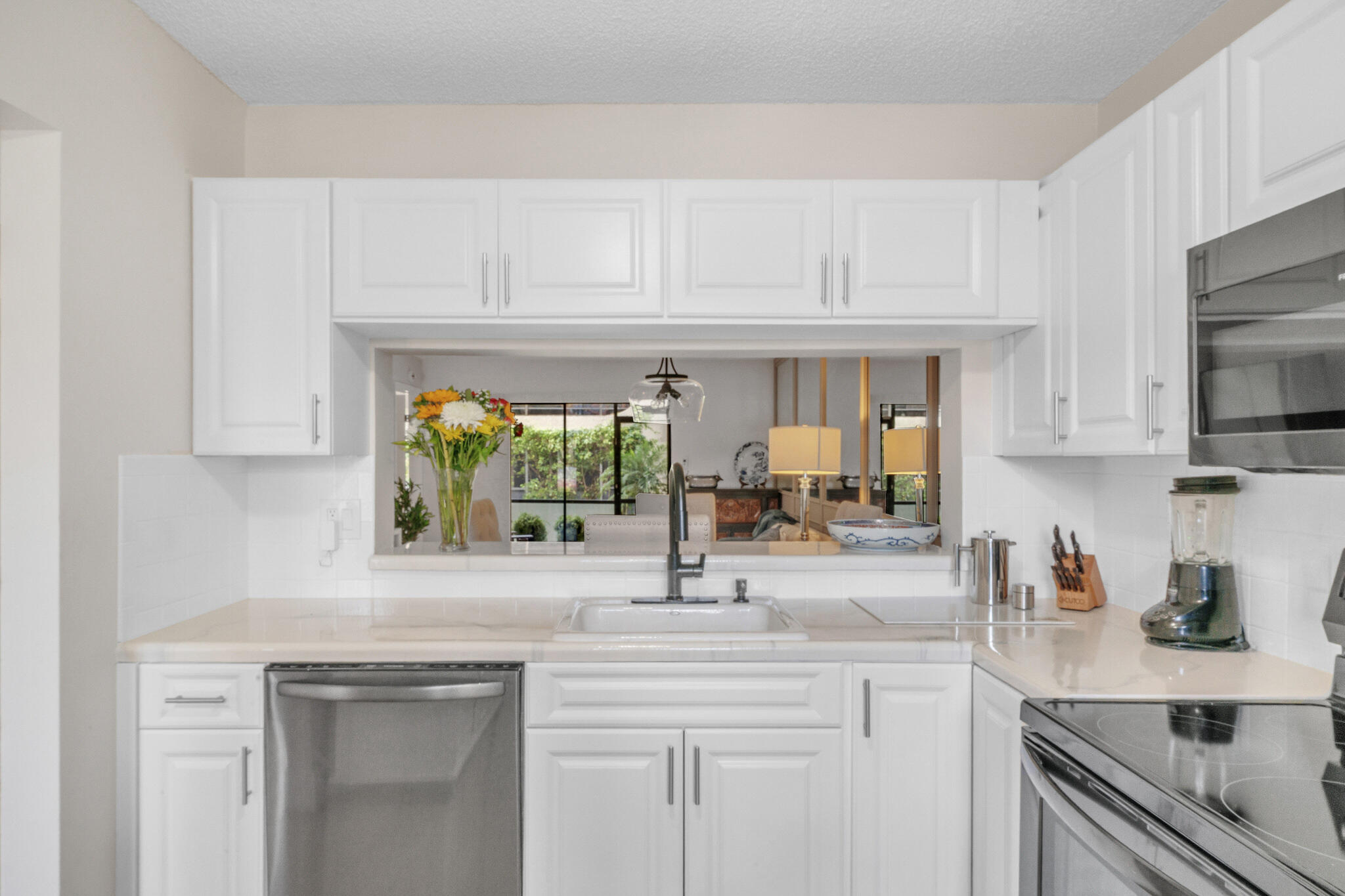 22136 Palms Way, Unit 103 Boca Raton, FL 33433 - Photo 6 of 42 a kitchen with white cabinets and a sink