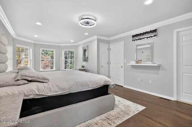 a bedroom with a large bed and wooden floor