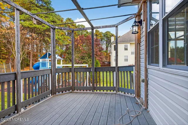 a view of a porch with wooden floor and iron fence