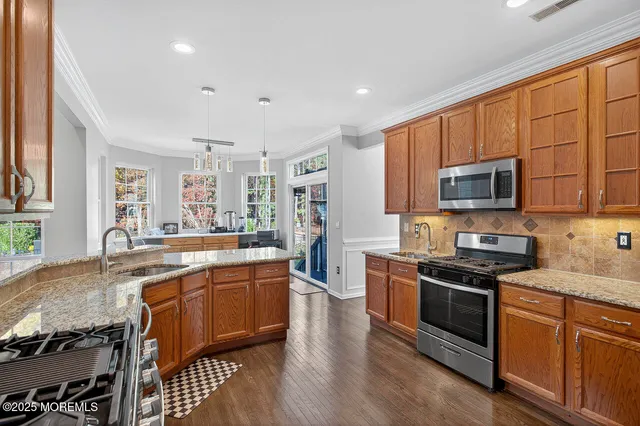 a large kitchen with stainless steel appliances granite countertop a stove and a sink