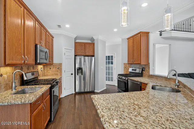 a kitchen with granite countertop a sink stove refrigerator and cabinets