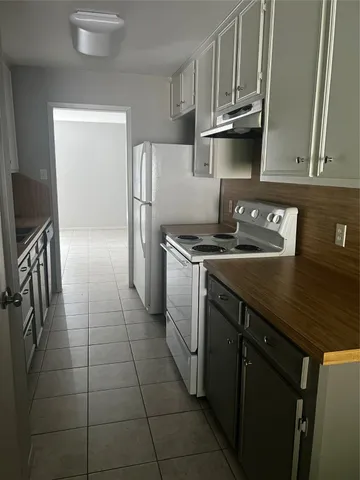 a kitchen with a stove top oven and cabinets