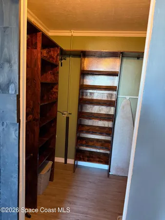 a view of walk in closet with empty racks
