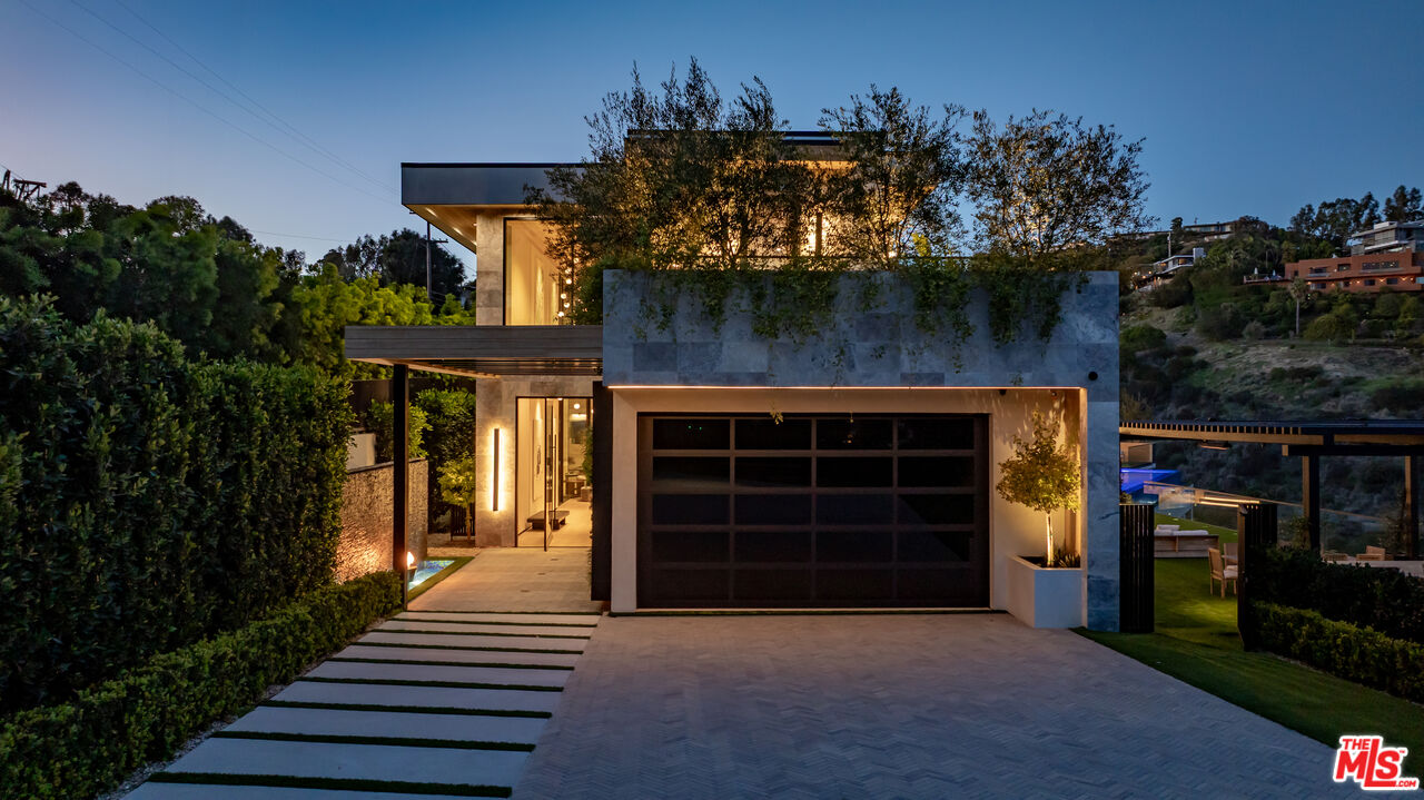 1104 North Tigertail Road Los Angeles, CA 90049 - Photo 2 of 27 a front view of a house with a yard