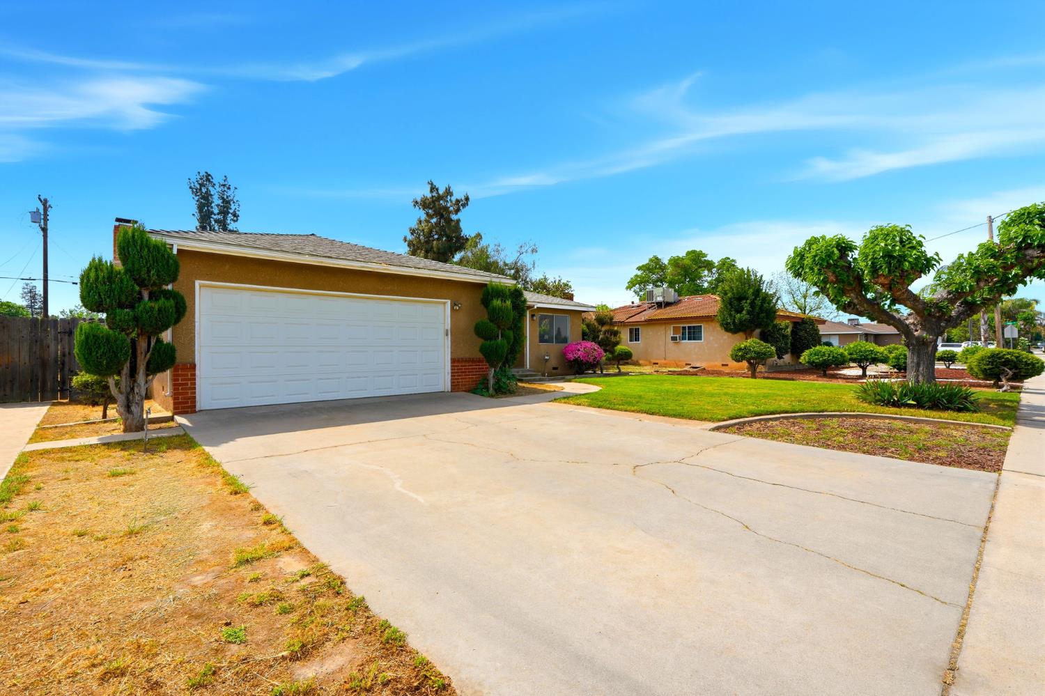 1123 East Washington Avenue Reedley, CA 93654 - Photo 3 of 53 a front view of a house with a yard and garage