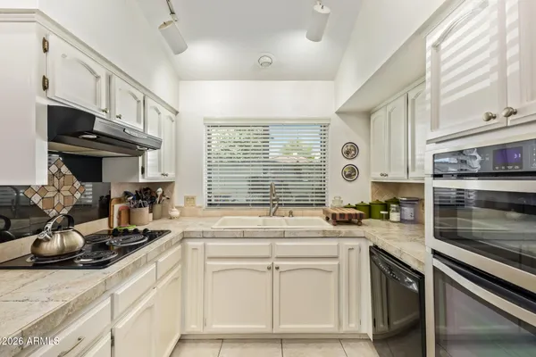 a kitchen with granite countertop a sink stove and cabinets
