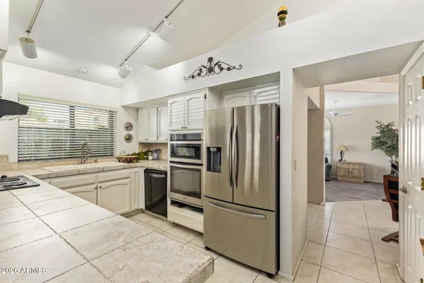 a kitchen with stainless steel appliances granite countertop a refrigerator and a stove top oven
